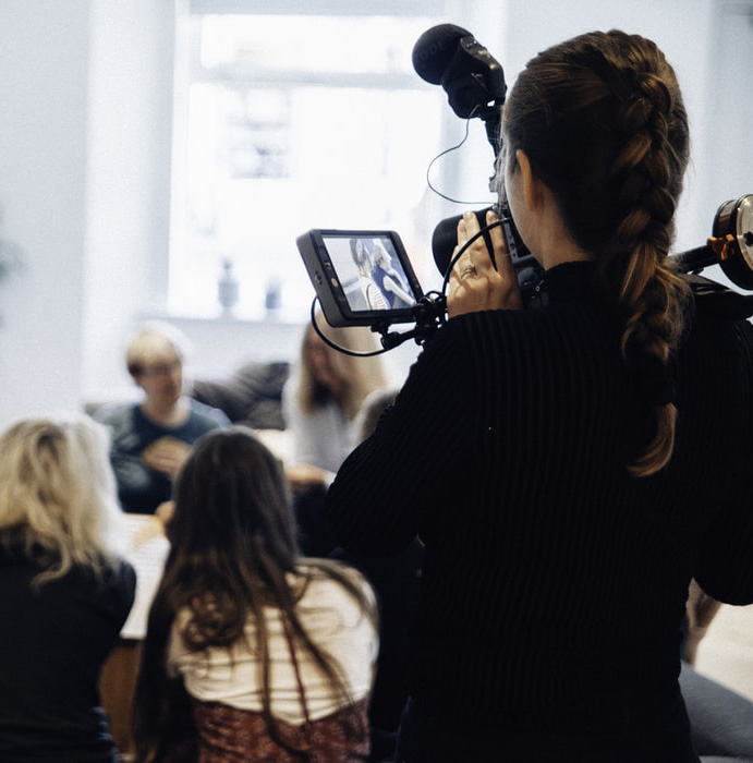 photo d'une caméraman qui film une conférence