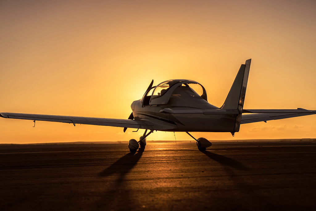 photo d'un avion monoplace au couché de soleil